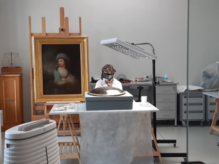 Pracownik muzeum podczas prac konserwatorskich przy tarczy